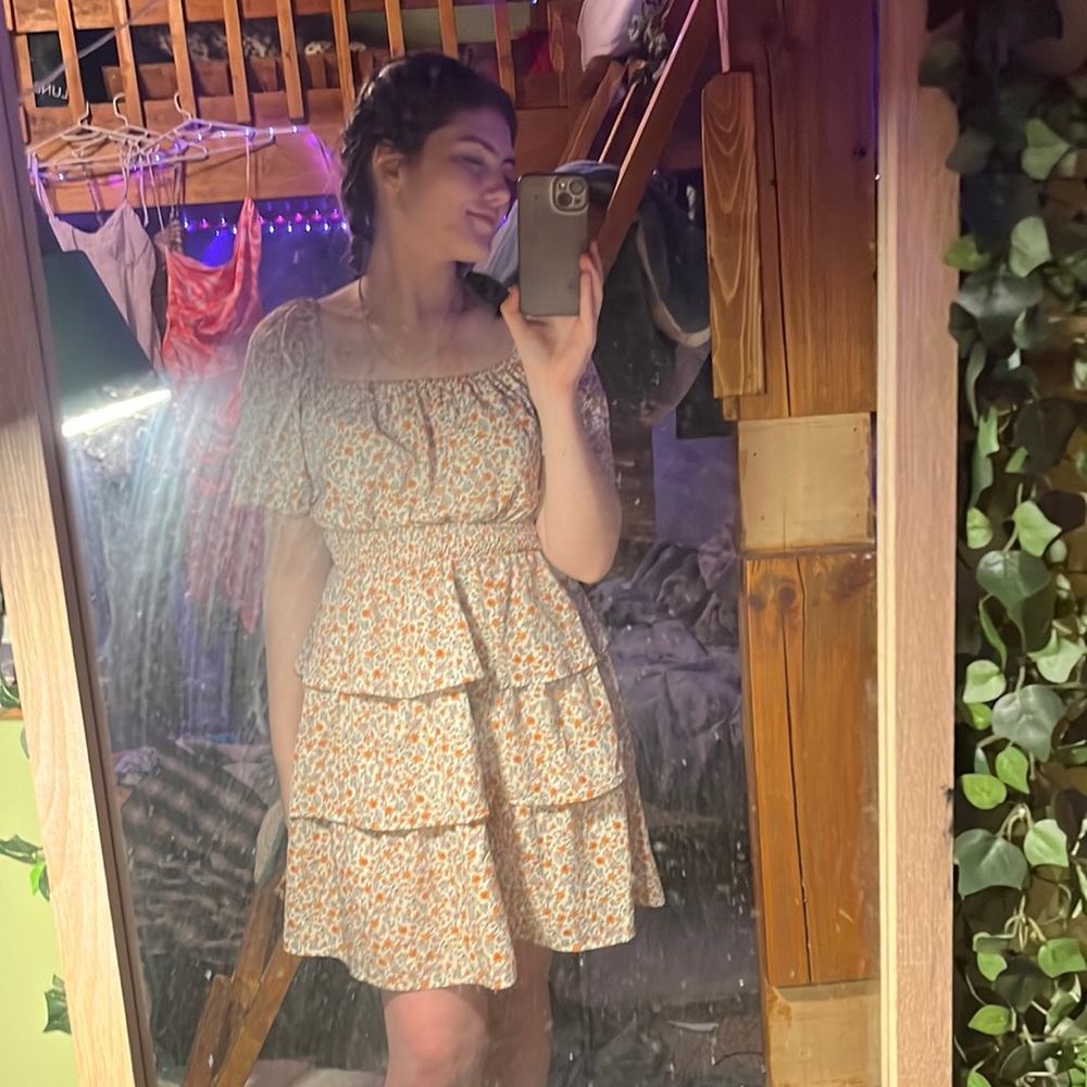 It’s a cute fall dress with orange flowers.